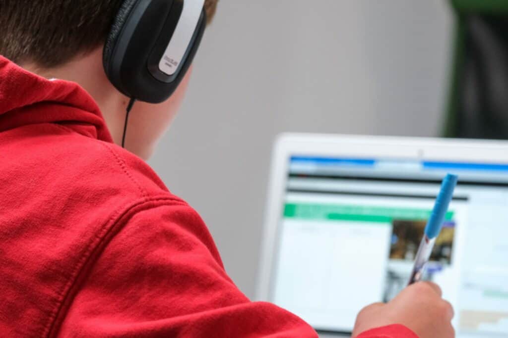 Un élève travaille sur ordinateur avec un casque audio pendant le cours